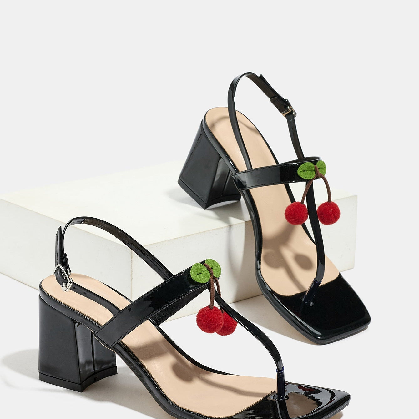 Mescini - Black square toe block heel sandal pair beside a white block, studio view, US