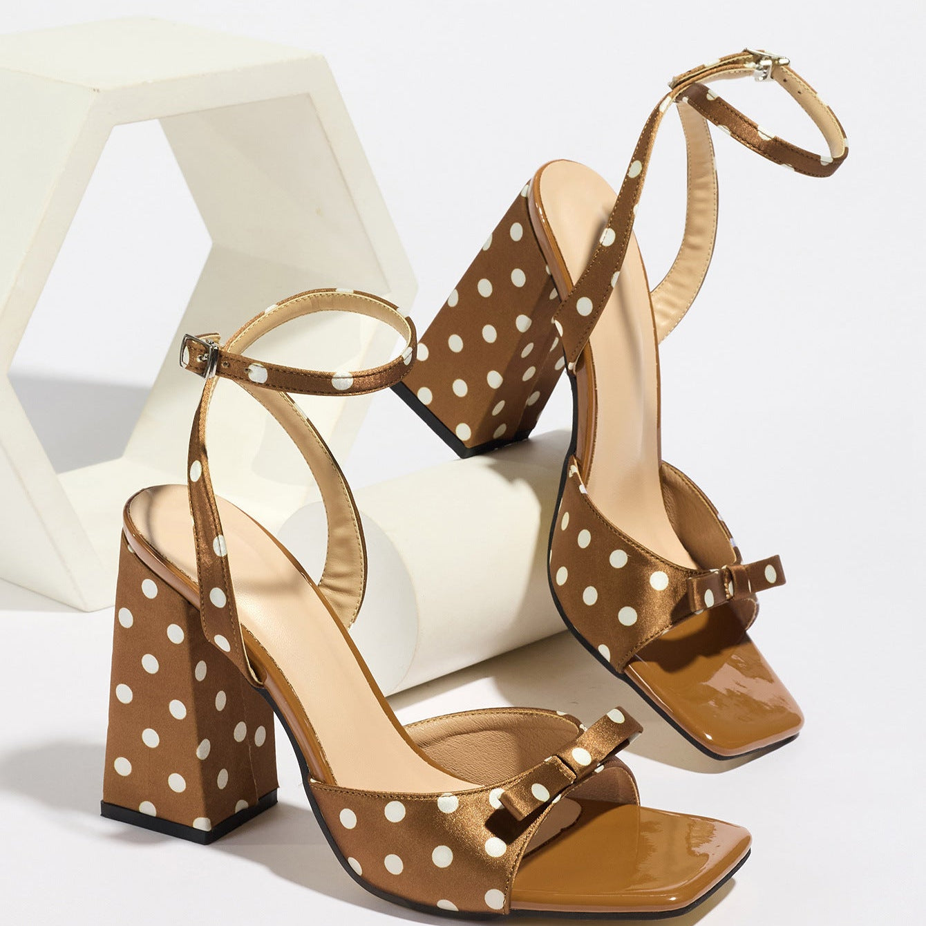 Mescini - Brown polka dot block heel sandal pair on a white riser, studio angle view, US