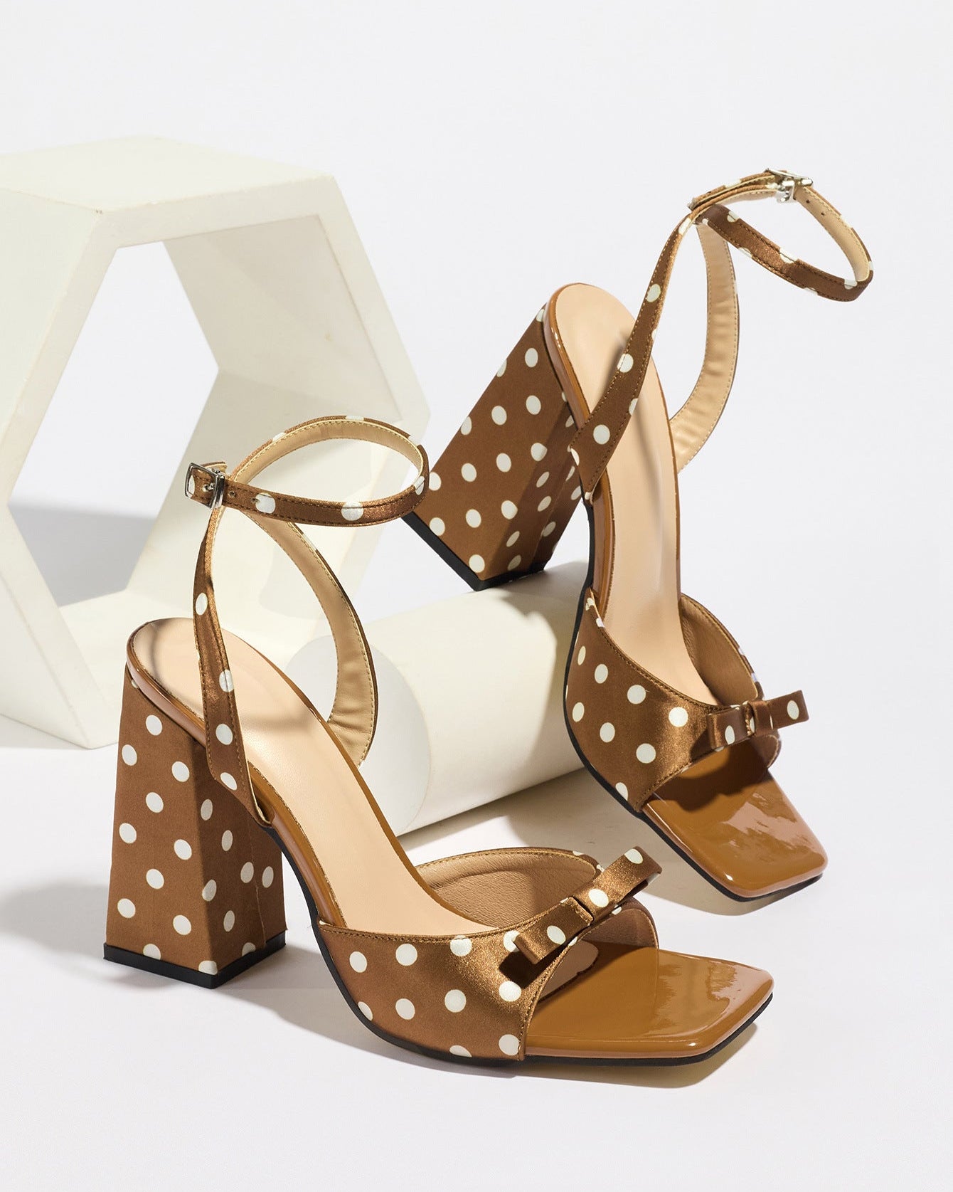 Mescini - Brown polka dot block heel sandal pair on a white riser, studio angle view, US