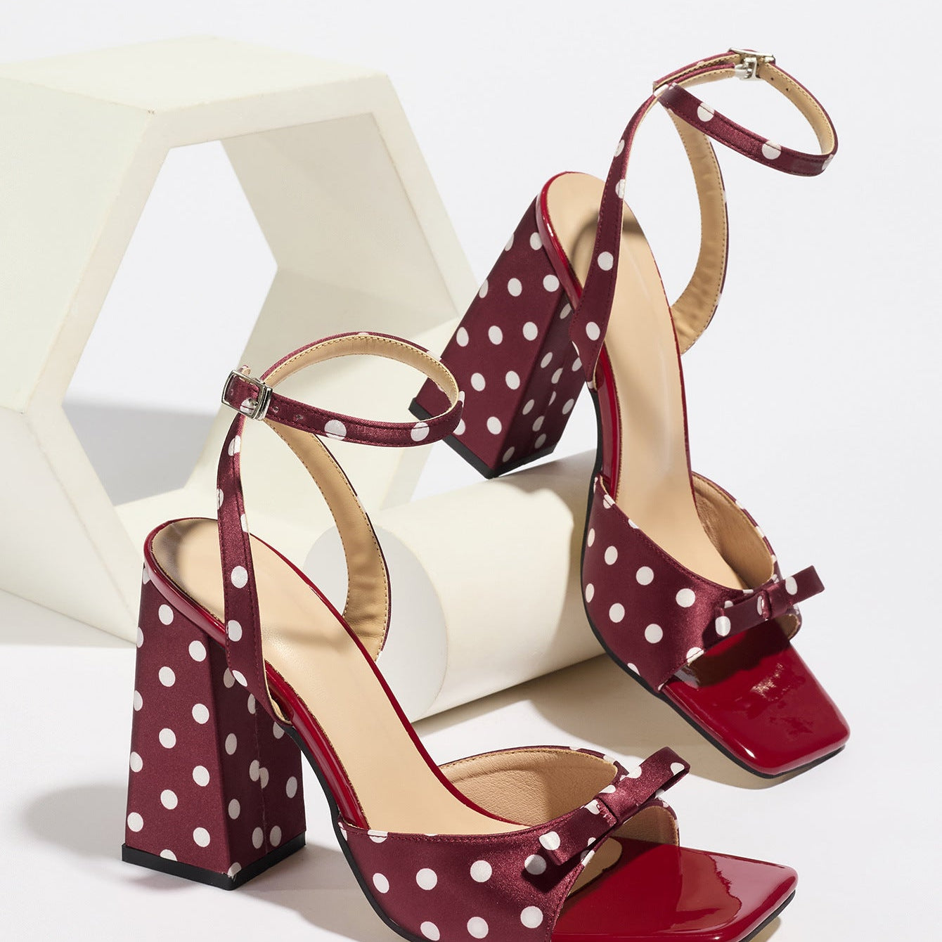 Mescini - Burgundy polka dot block heel sandal pair on a white riser, studio view, US