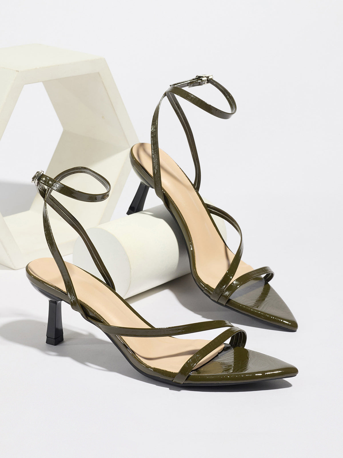 Mescini olive strappy heeled sandals, pair propped on white display blocks, US women's sizes