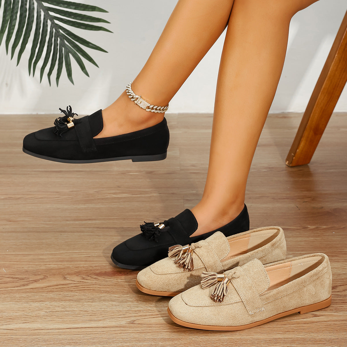 Mescini black and tan tassel loafer flats, one pair worn and one on a wood floor, US women's sizes