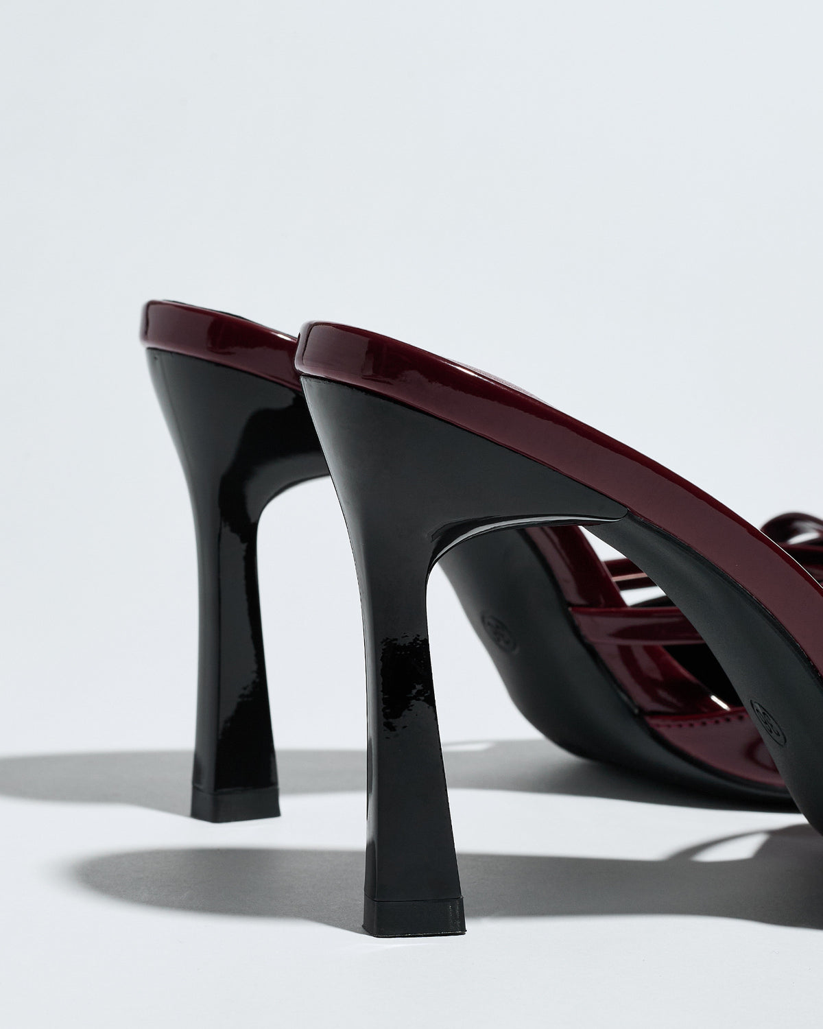 Mescini burgundy bow pointed toe stiletto mules, close up of the flared heels, US women's sizes