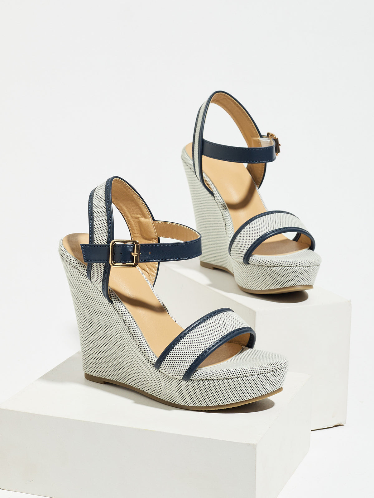 Mescini navy blue canvas platform wedge sandals, one shoe posed on a white riser, US women's sizes