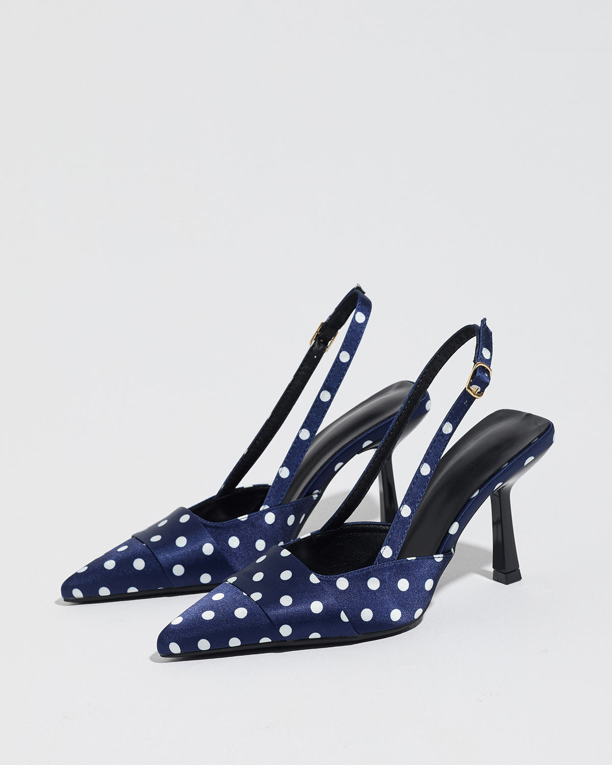 Mescini navy polka dot slingback stiletto heels, pair angled on a pale studio floor, US women's sizes