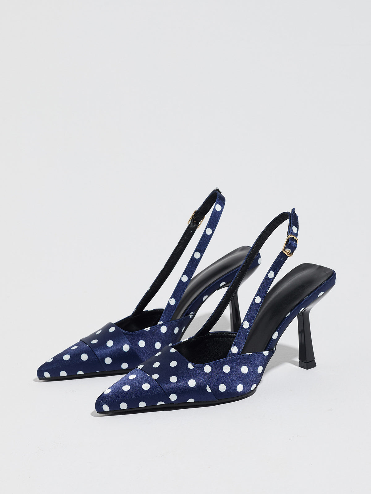 Mescini navy polka dot slingback stiletto heels, pair angled on a pale studio floor, US women's sizes