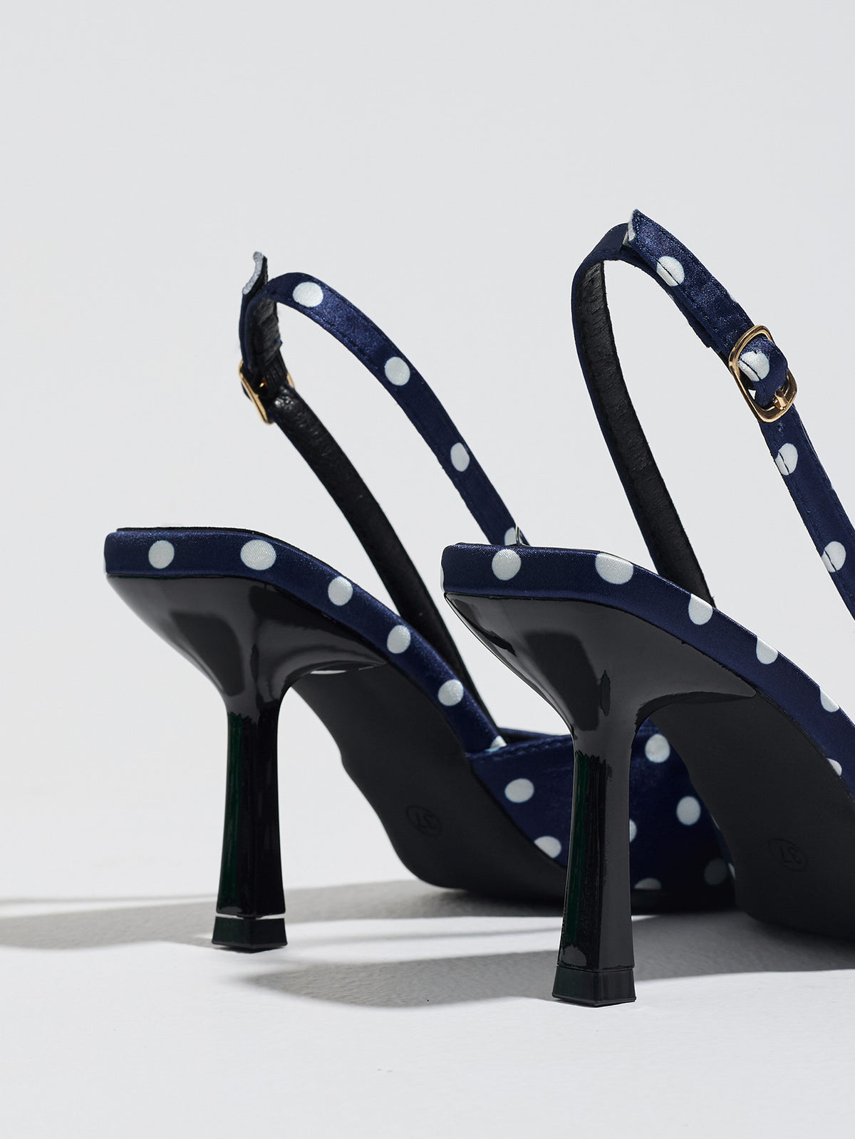 Mescini navy polka dot slingback stiletto heels, rear view showing the buckle strap, US women's sizes