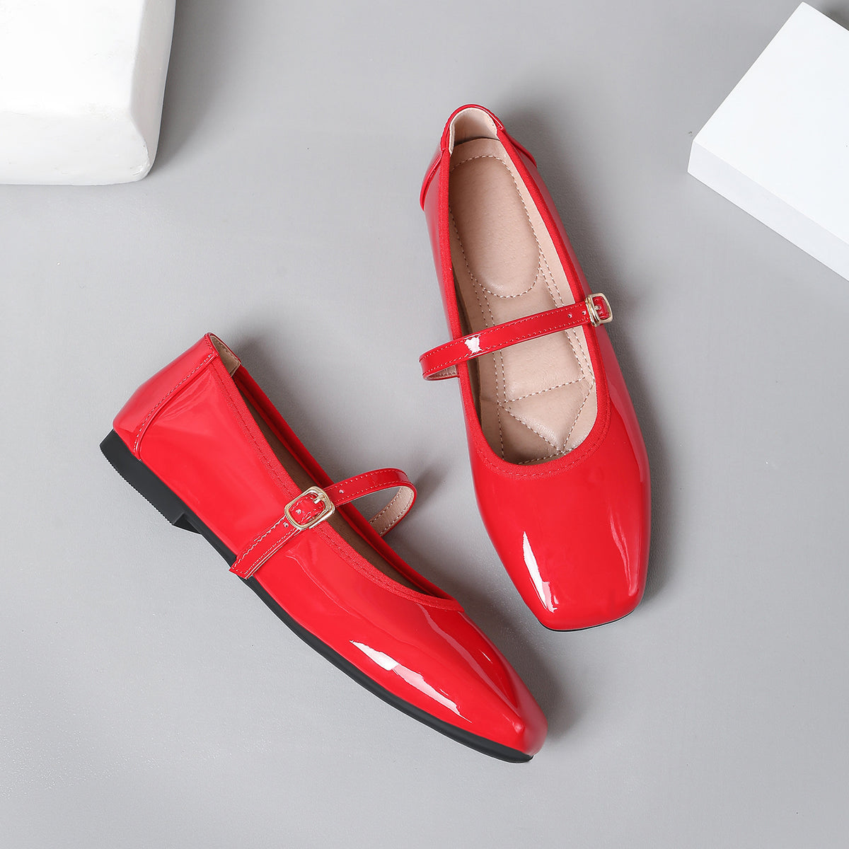 Mescini red patent square toe mary jane flats, pair with one shoe tipped on its side, US women's sizes