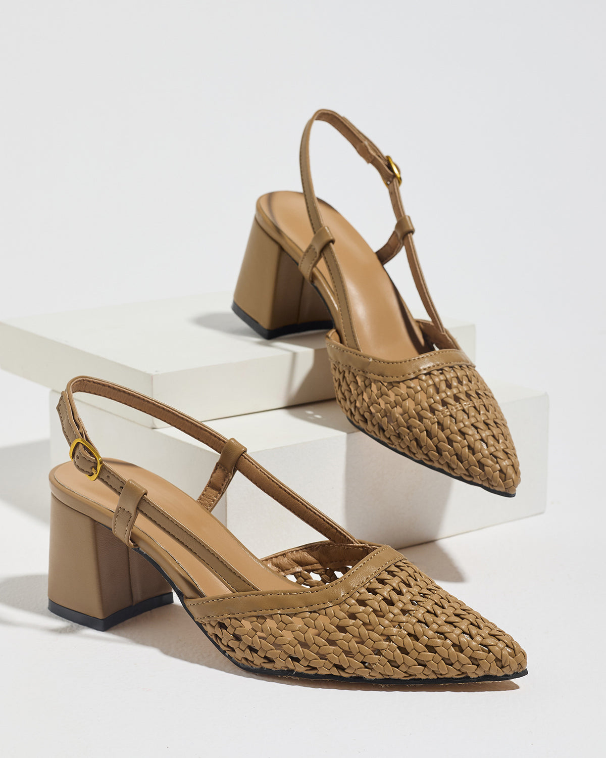 Mescini brown woven pointed toe block heel pumps, pair on white display risers, US women's sizes