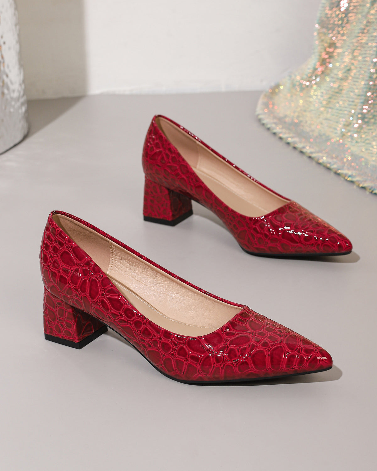 Mescini wine red croc embossed block heel pumps, the pair set on a pale step, US women's sizes