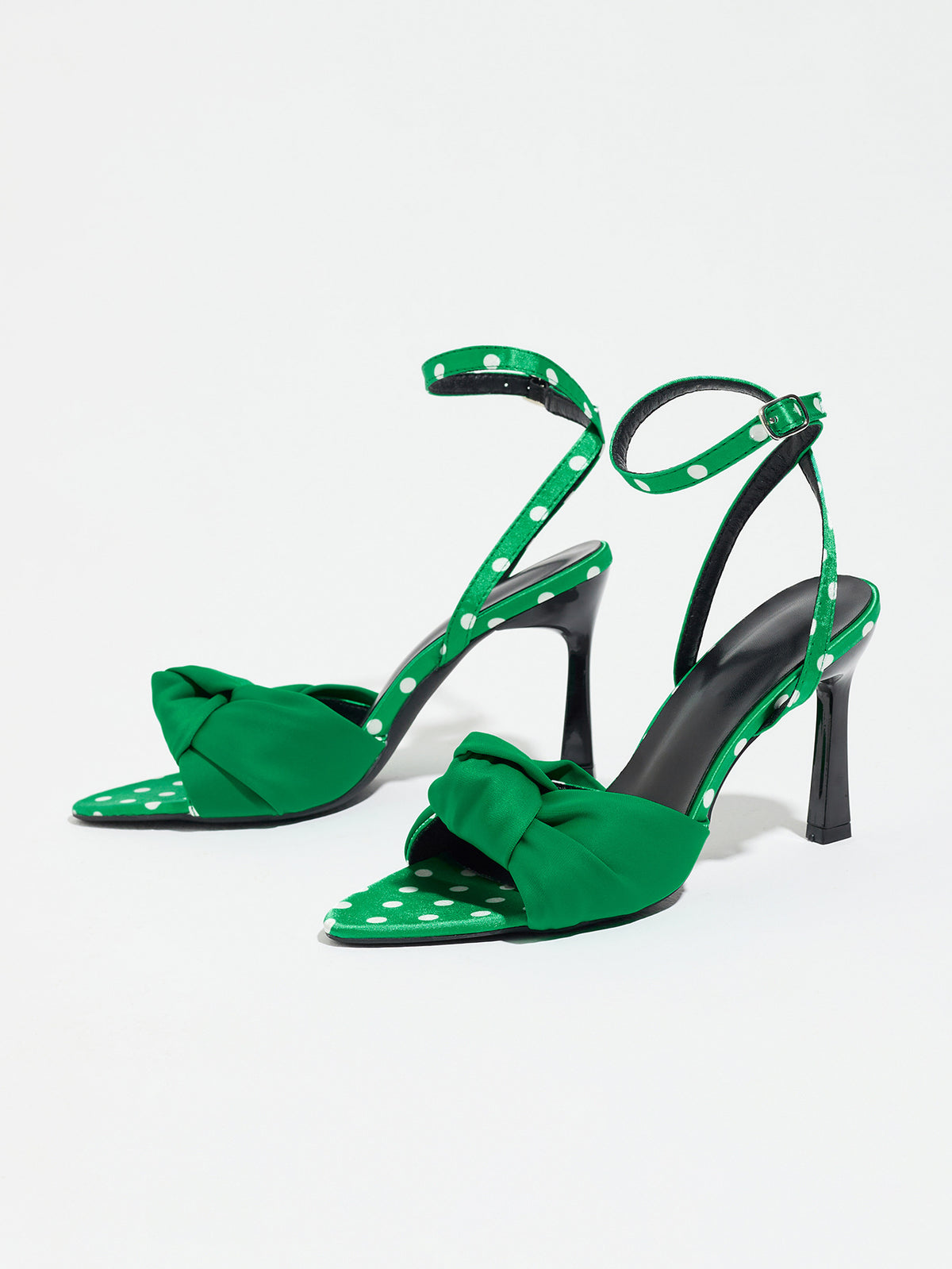 Mescini green knot front polka dot heeled sandals, pair photographed at a low angle, US women's sizes