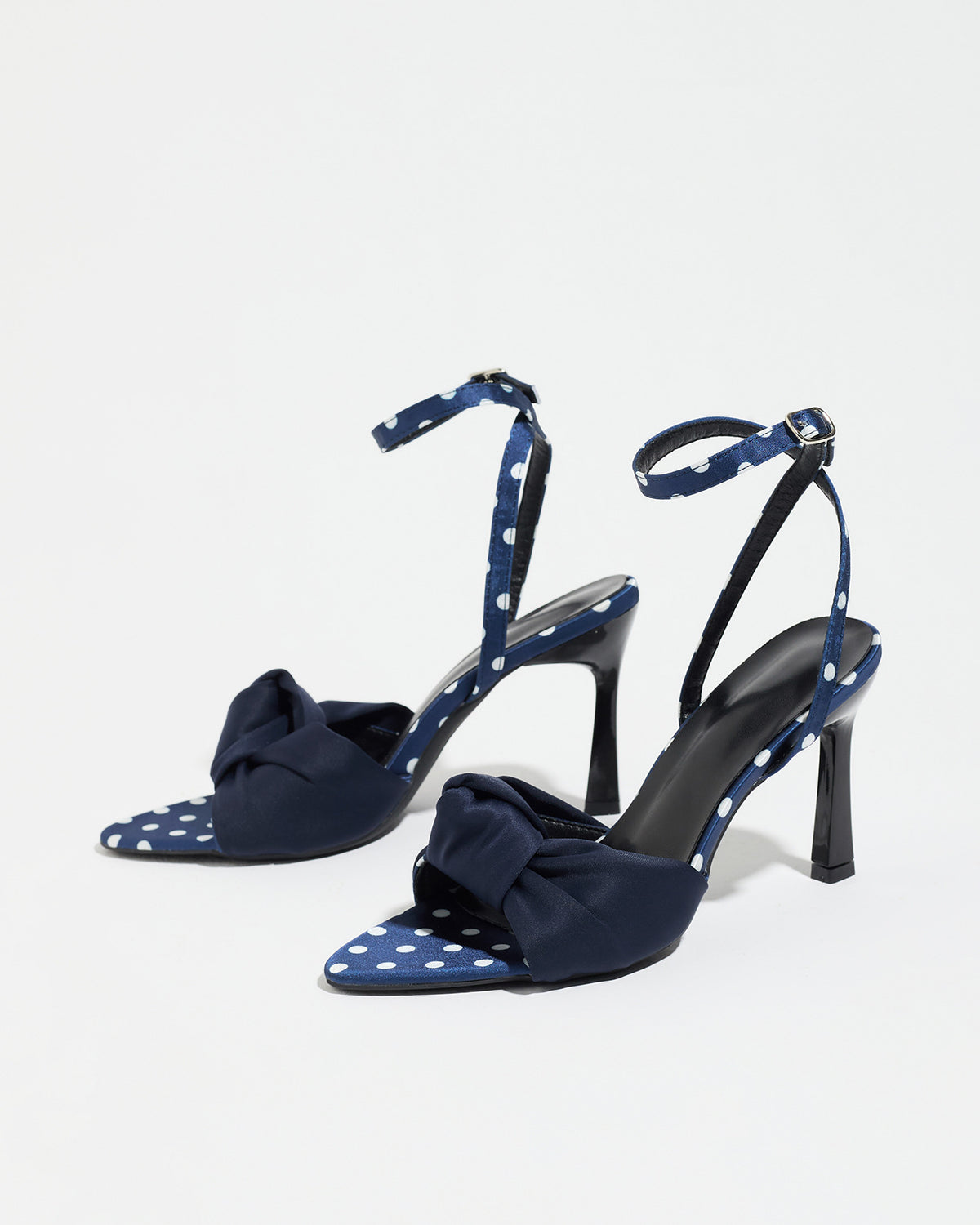 Mescini navy knot front polka dot heeled sandals, pair seen at an angle on white, US women's sizes