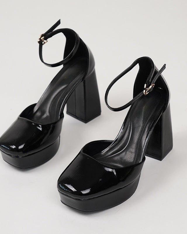 Mescini black patent platform ankle strap heels, the pair angled on a white studio floor, US women's sizes