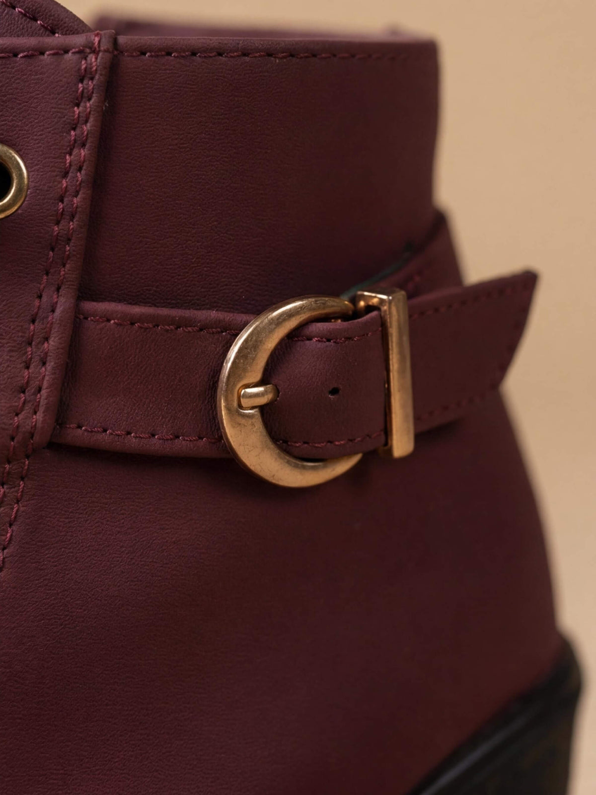 Close crop of the antique gold buckle strap on Mescini burgundy lace up ankle boots