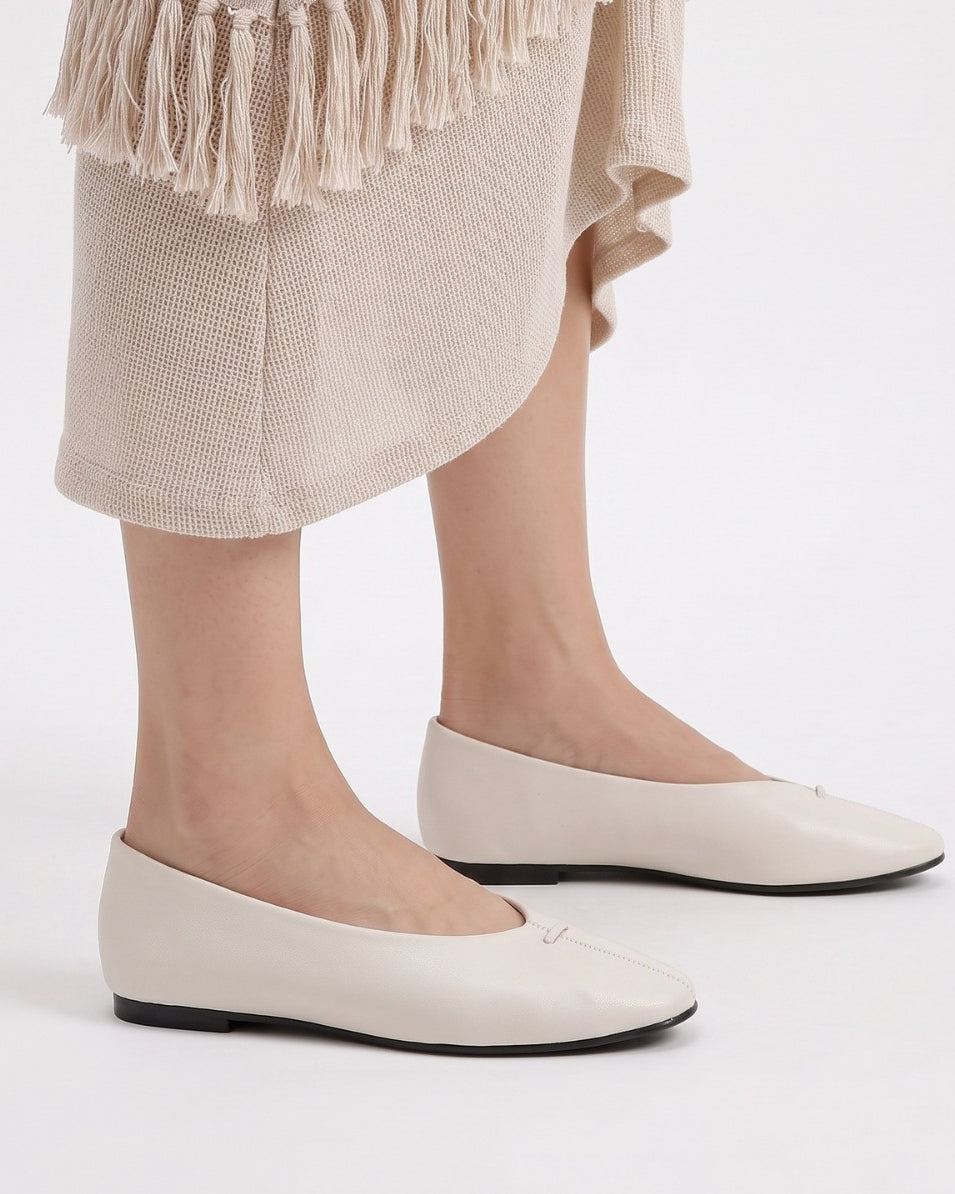 Mescini - off-white ballet flats worn standing under a knit skirt, US women's sizes