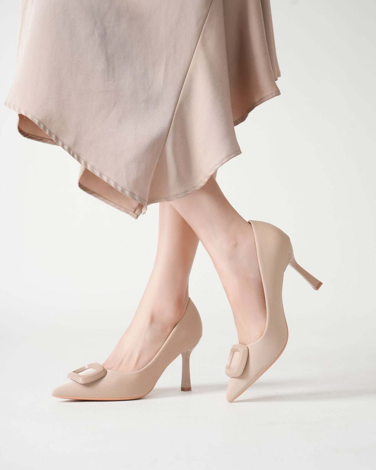 Mescini beige square ring pointed toe pumps worn with the legs crossed, US women's sizes
