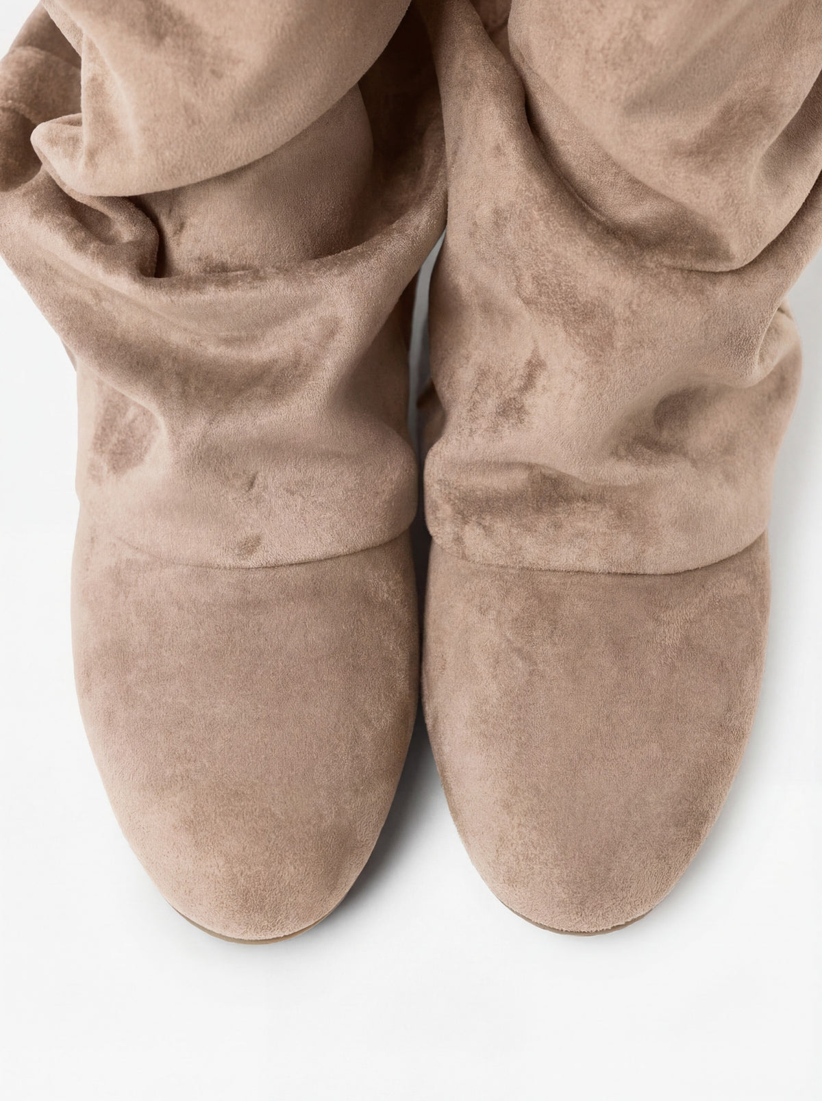 Mescini beige slouchy mid calf boots, worn on the leg beside a pale rug, US sizes