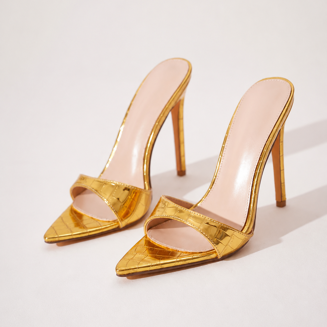Mescini gold croc embossed pointed stiletto mules, the pair angled on a cream background, US women's sizes