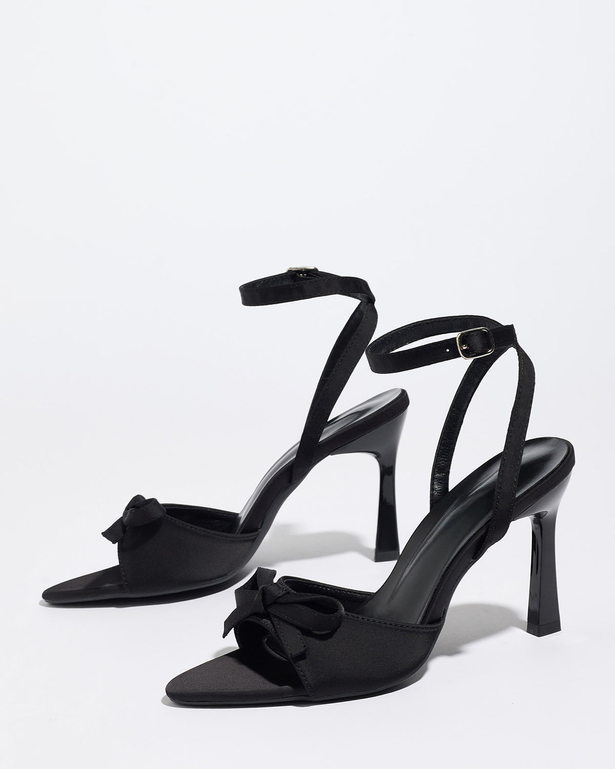Mescini black satin bow ankle strap sandals, angled pair standing on a white surface, US women's sizes