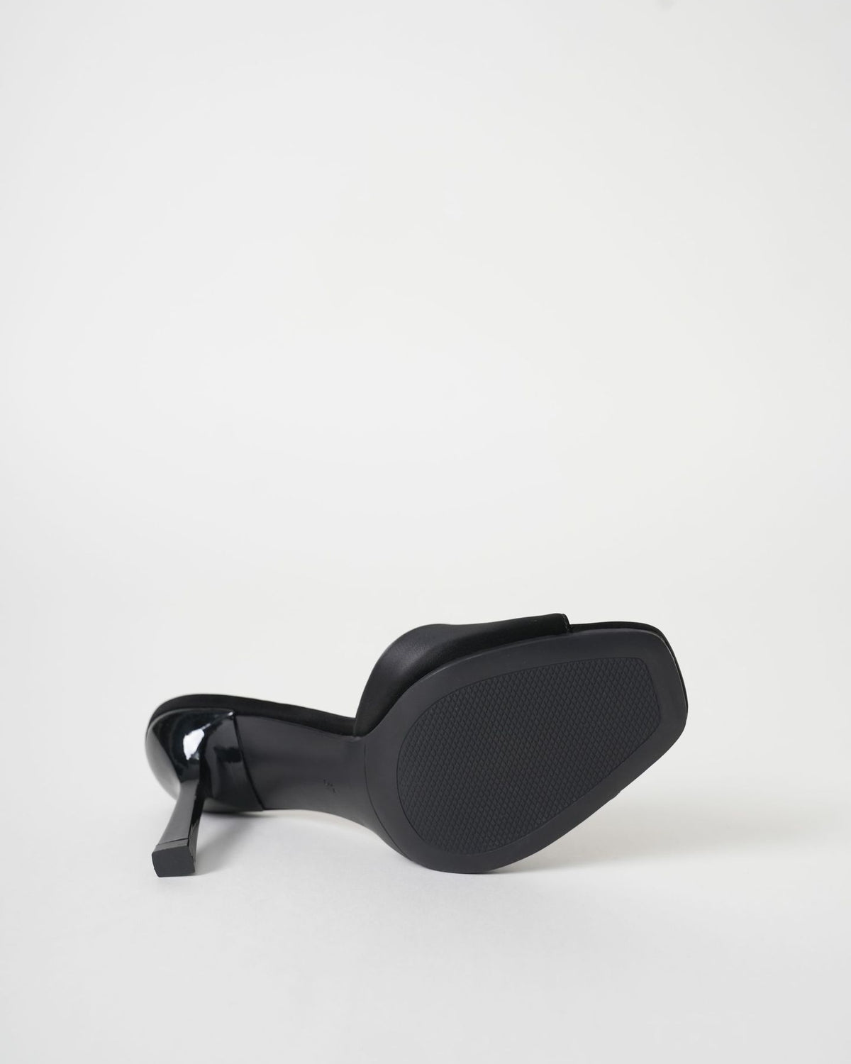 Mescini black wide band square toe mule on its side, the outsole facing out, US women's sizes