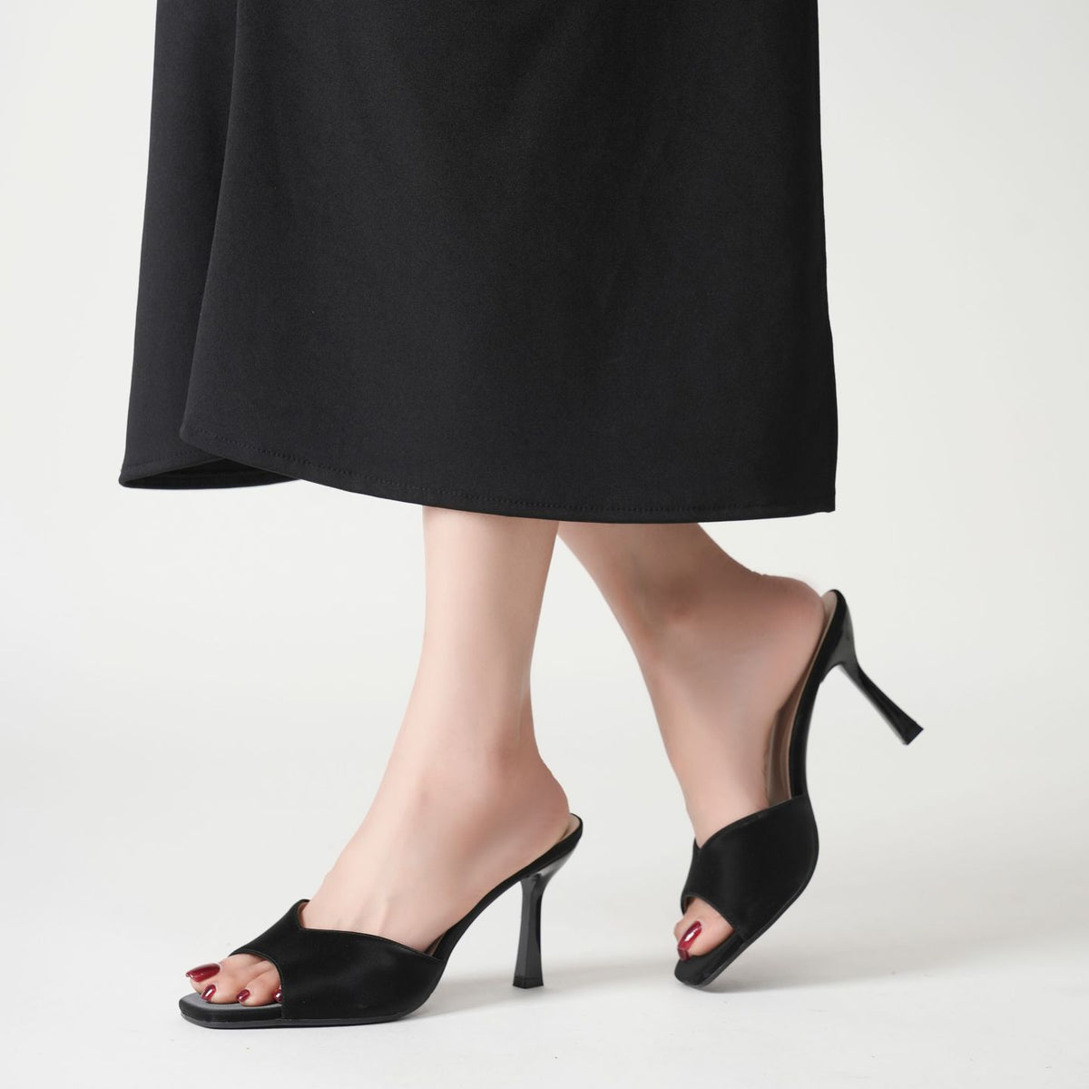 Mescini black wide band square toe mules worn with a long dark skirt, walking, US women's sizes