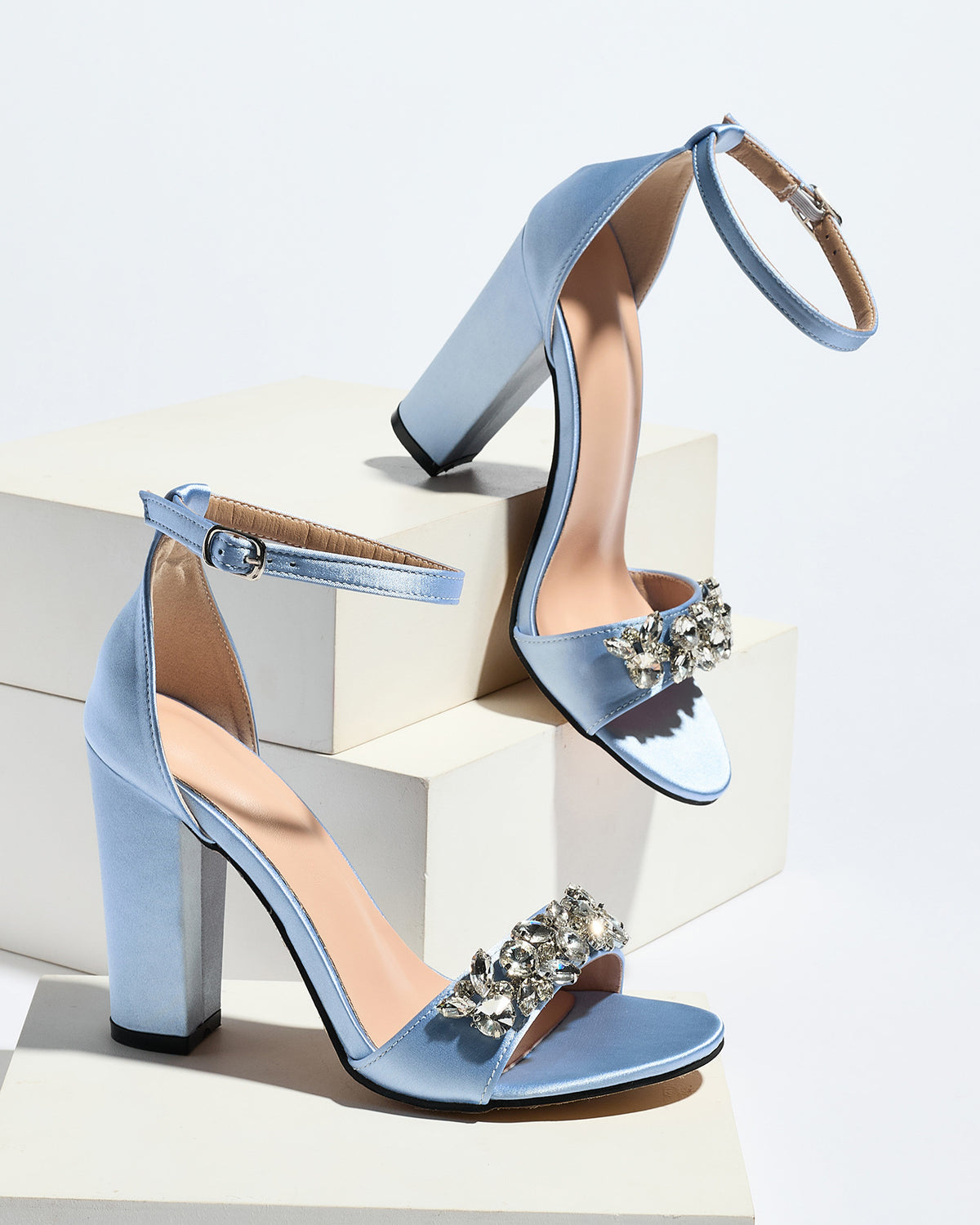 Mescini light blue crystal strap block heel sandals, pair posed on white display blocks, US women's sizes