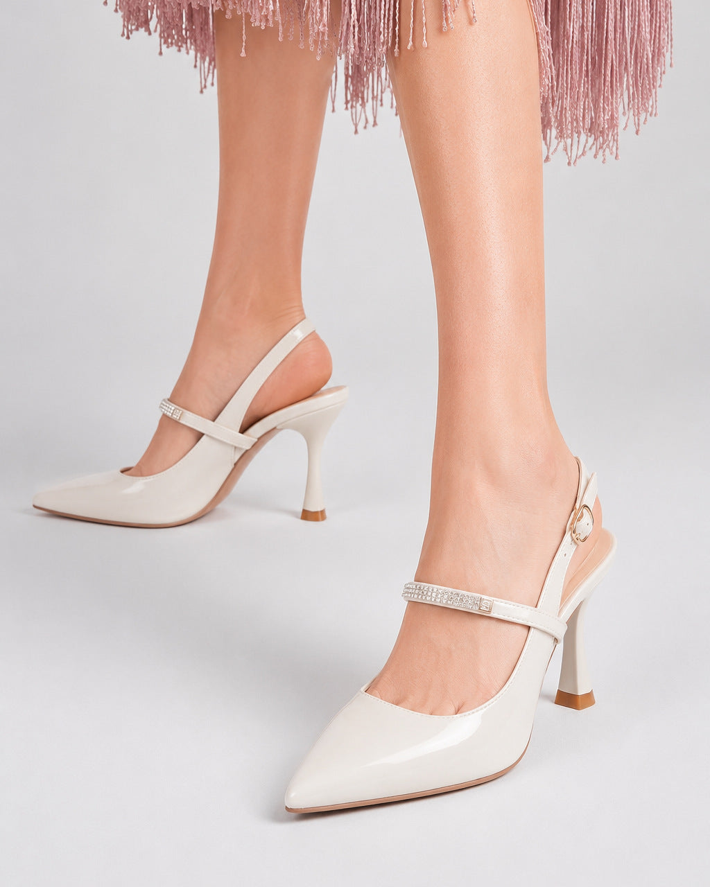 Mescini white crystal strap pointed slingback pumps, worn on the model mid stride, US women's sizes