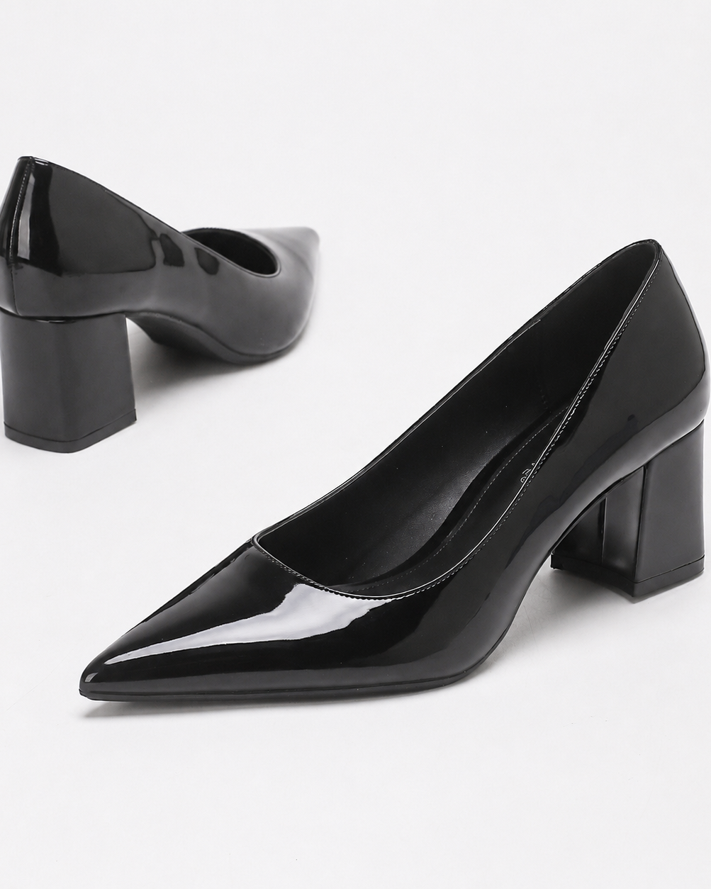Mescini black high shine pointed toe block heel pumps, the pair angled on a white ground, US women's sizes