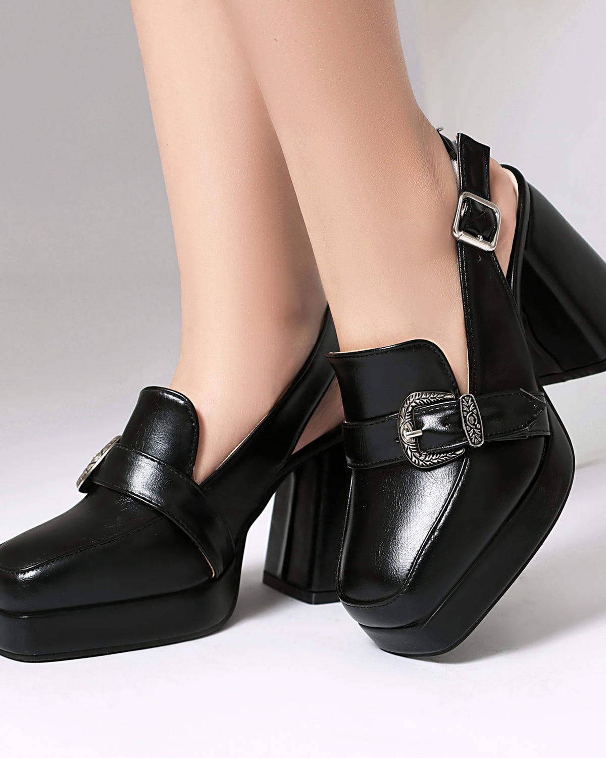 Mescini black square toe platform slingback loafers, worn close up, one foot forward, US women's sizes