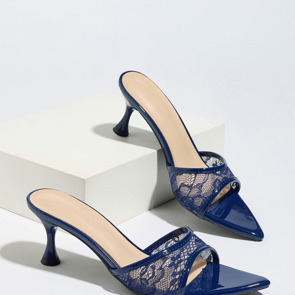 Mescini navy sheer lace pointed toe mule heels, pair staged on a white display block, US women's sizes
