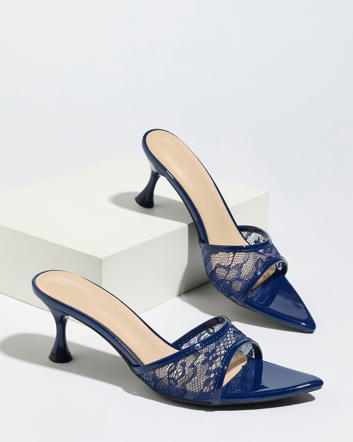 Mescini navy sheer lace pointed toe mule heels, pair staged on a white display block, US women's sizes