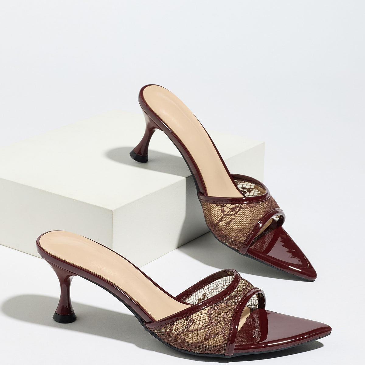 Mescini burgundy sheer lace pointed toe mule heels, pair resting on a white block, US women's sizes