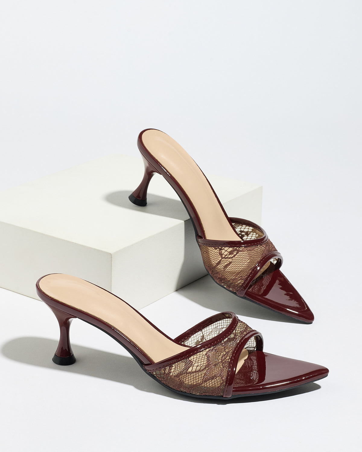 Mescini burgundy sheer lace pointed toe mule heels, pair resting on a white block, US women's sizes