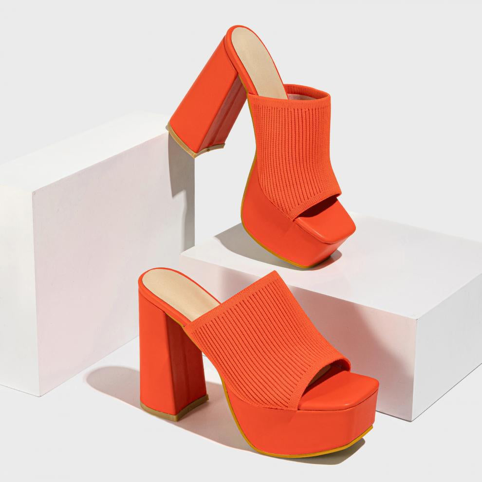 Mescini orange knit band platform mule heels, pair staged on stacked white blocks, US women's sizes