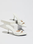 Mescini - White pointed toe mule heels as a pair on white risers, studio view, US sizes