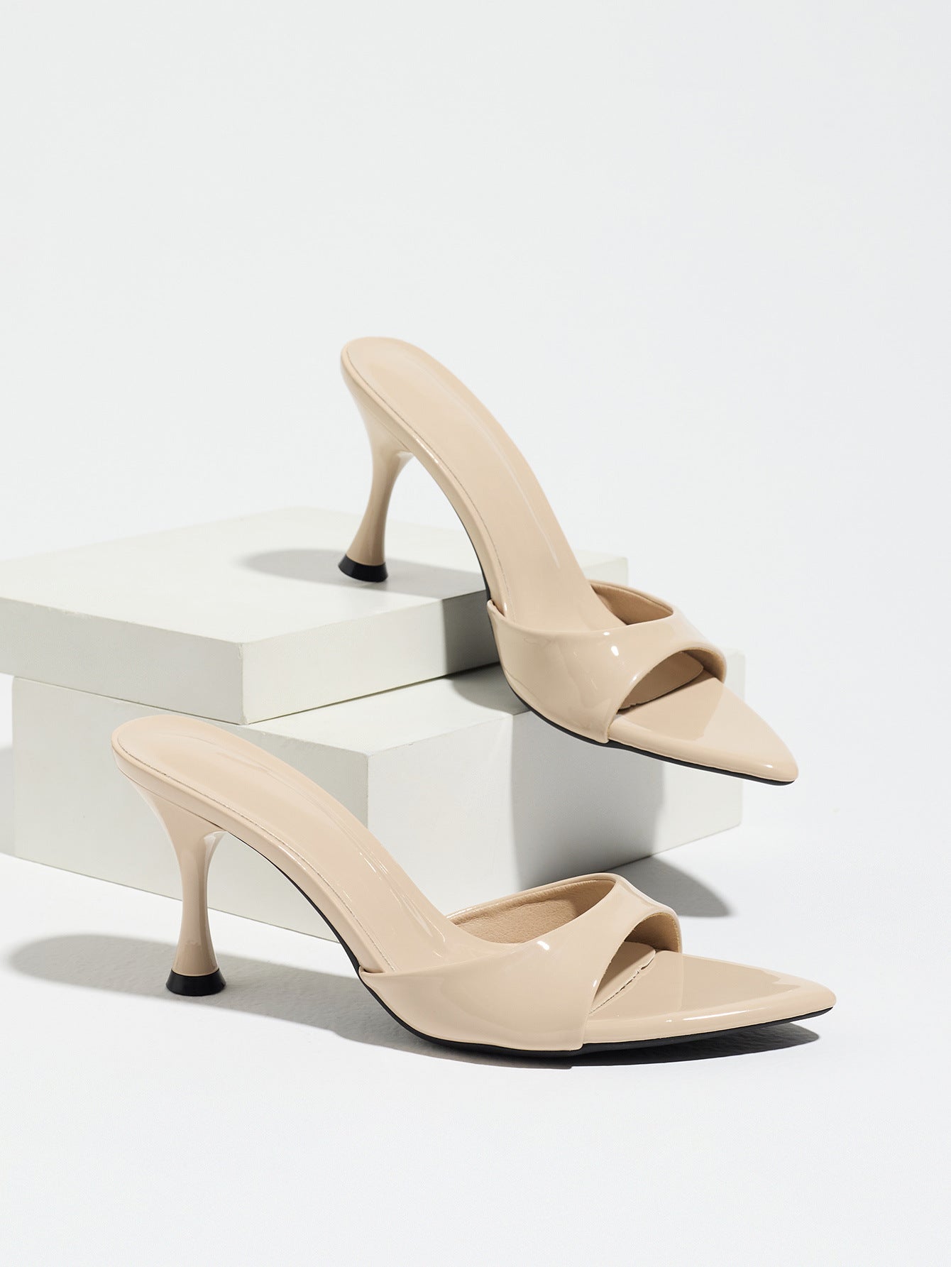 Mescini - Nude pointed toe mule heels as a pair on white risers, studio view, US sizes