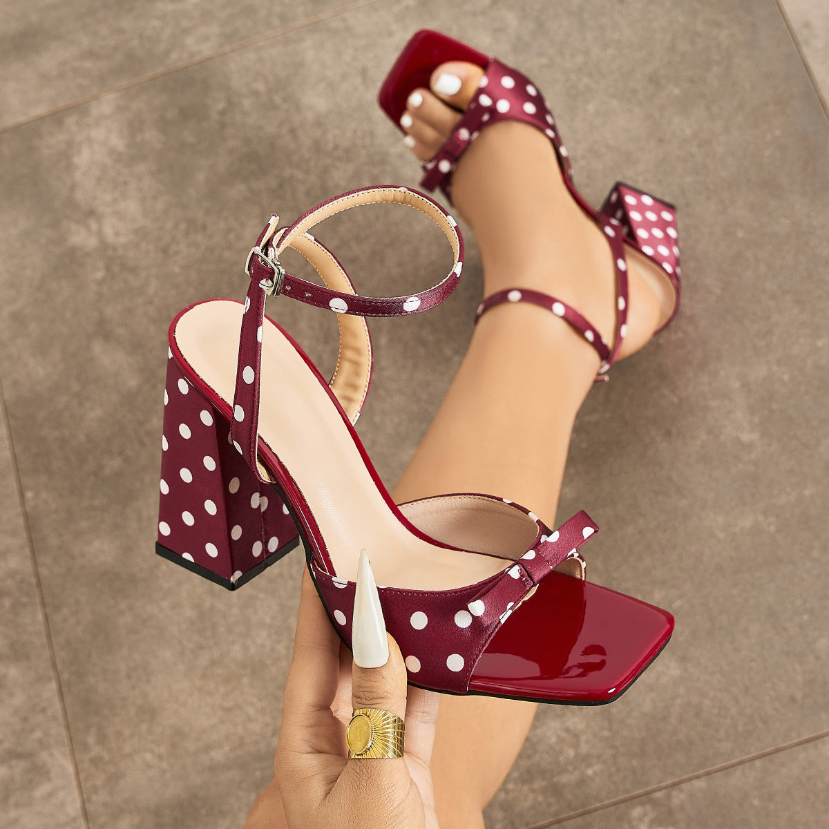Mescini - Burgundy polka dot block heel sandal held in hand, square toe cap view, US sizes
