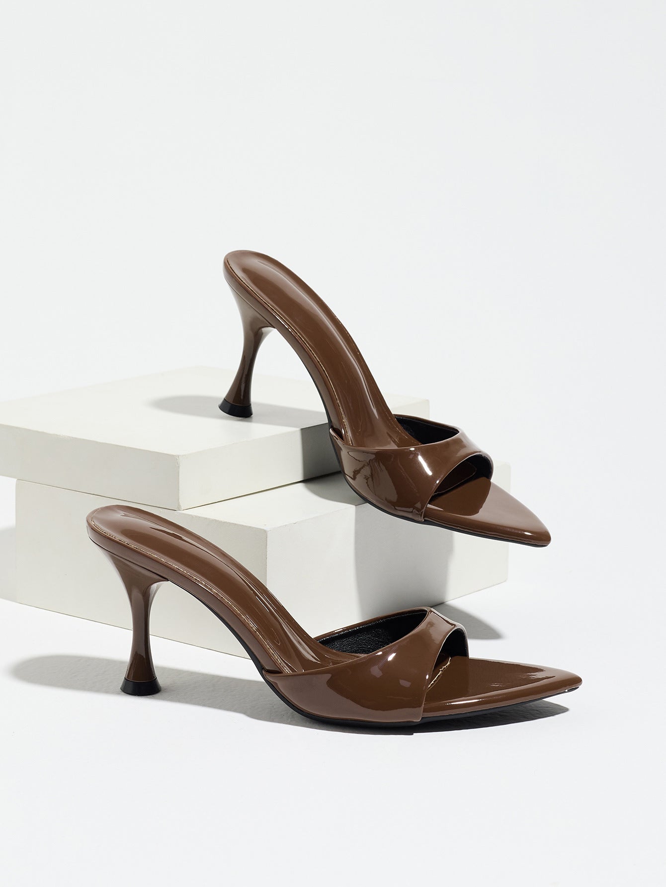Mescini - Brown pointed toe mule heels as a pair on white risers, studio view, US sizes