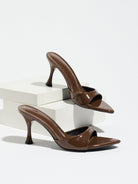 Mescini - Brown pointed toe mule heels as a pair on white risers, studio view, US sizes