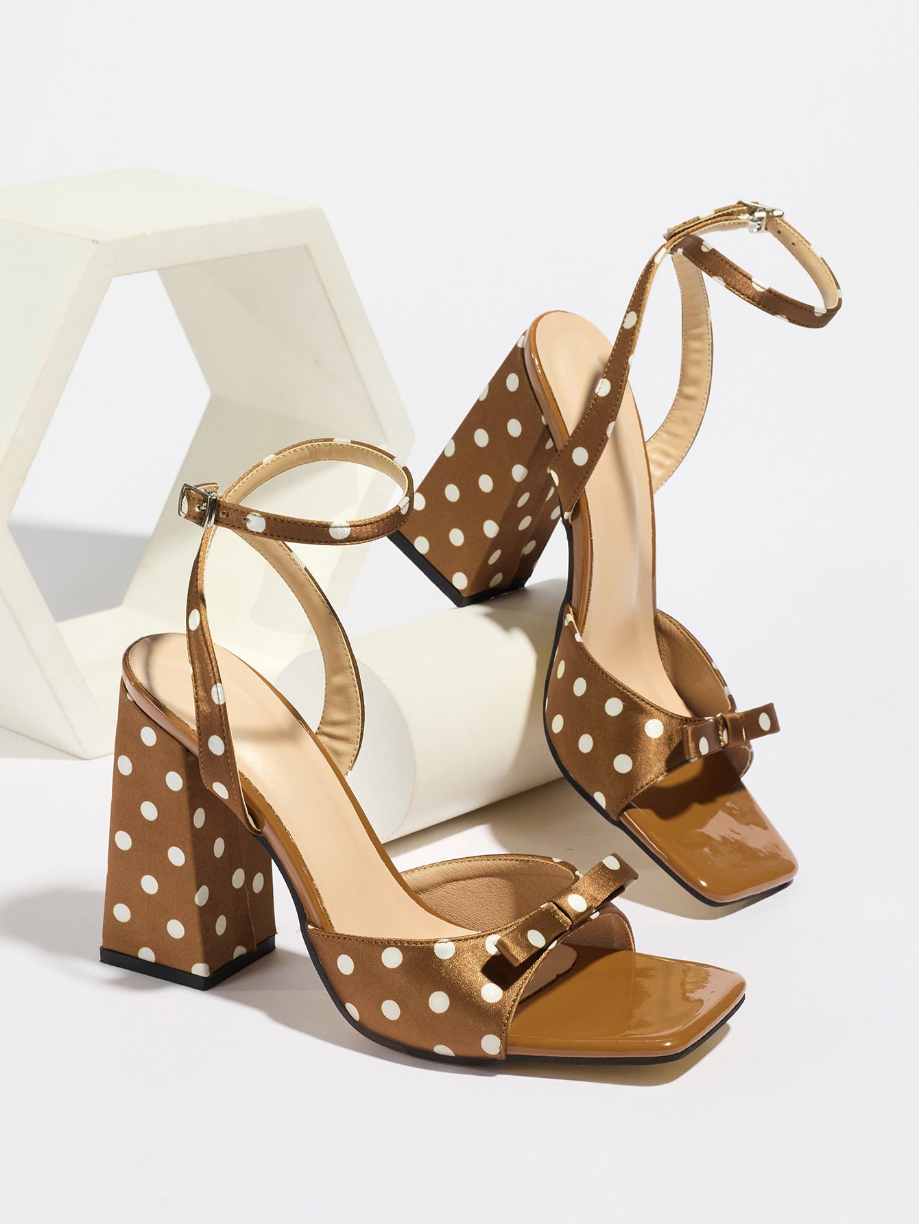 Mescini - Brown polka dot block heel sandal pair on a white riser, studio angle view, US