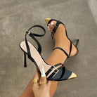 Mescini - Black ankle strap heels held in hand, overhead view of the pair, US women's sizes