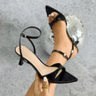 Mescini - Black kitten heel sandal held beside the foot, pointed toe detail, US sizes