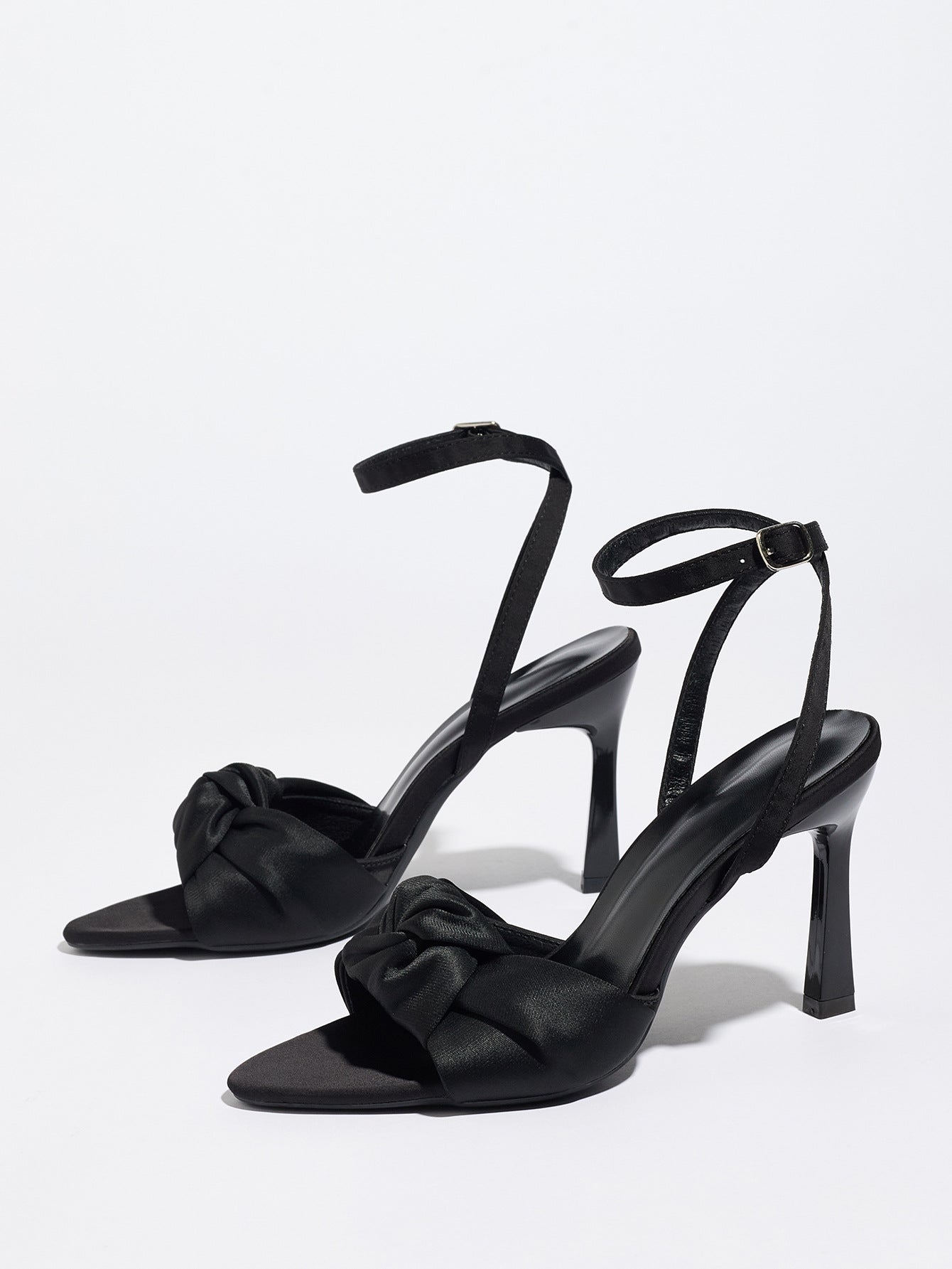 Mescini black knotted satin ankle strap sandals, pair angled on a plain surface, US women's sizes