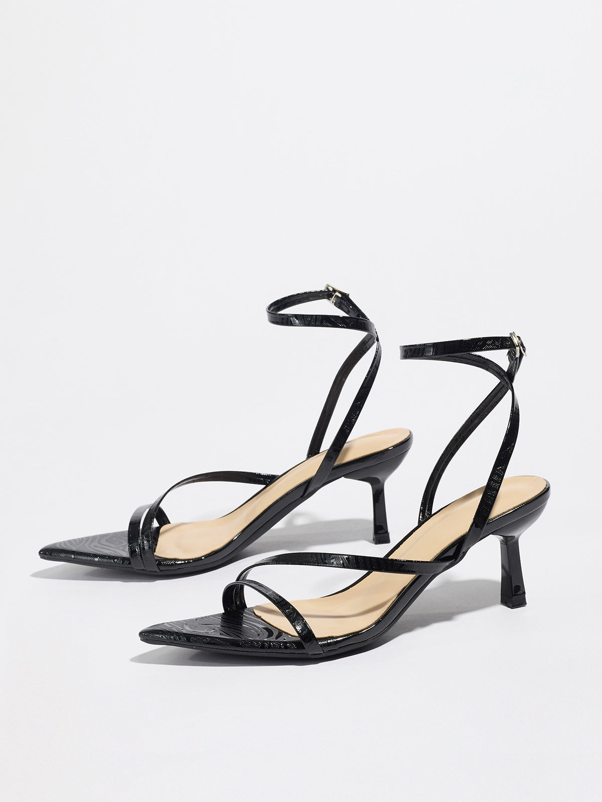 Mescini black strappy heeled sandals, angled pair on a white studio floor, US women's sizes