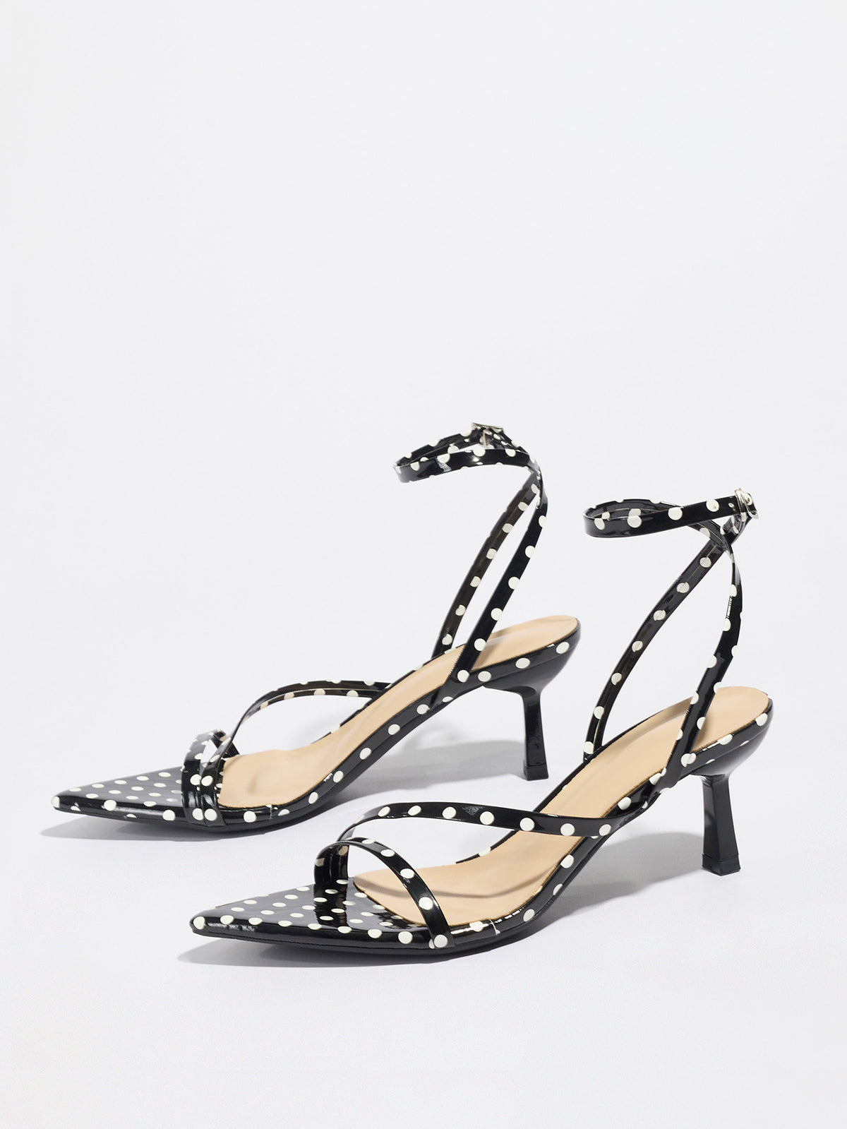 Mescini black polka dot strappy heeled sandals, angled pair on a grey floor, US women's sizes