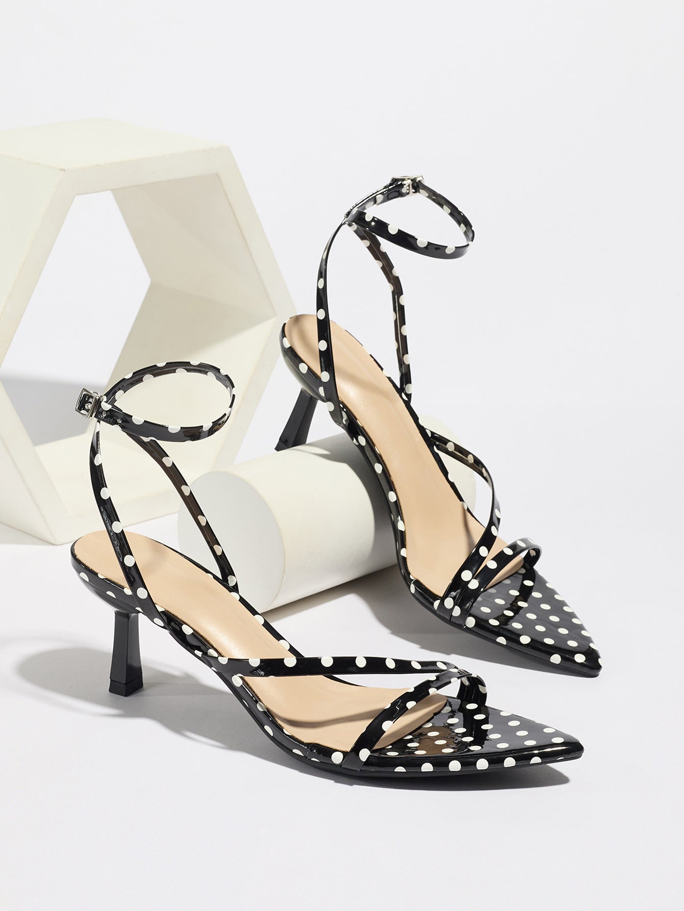 Mescini black polka dot strappy heeled sandals, pair propped on pale blocks, US women's sizes