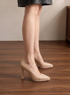 Mescini nude sculpted heel pointed toe pumps, worn standing in a side view, US women's sizes