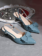 Mescini blue bow pointed toe slingback kitten heels, pair placed next to a carved mirror, US women's sizes