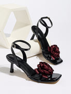 Mescini black rosette square toe strappy sandals, pair posed beside a white block, US women's sizes