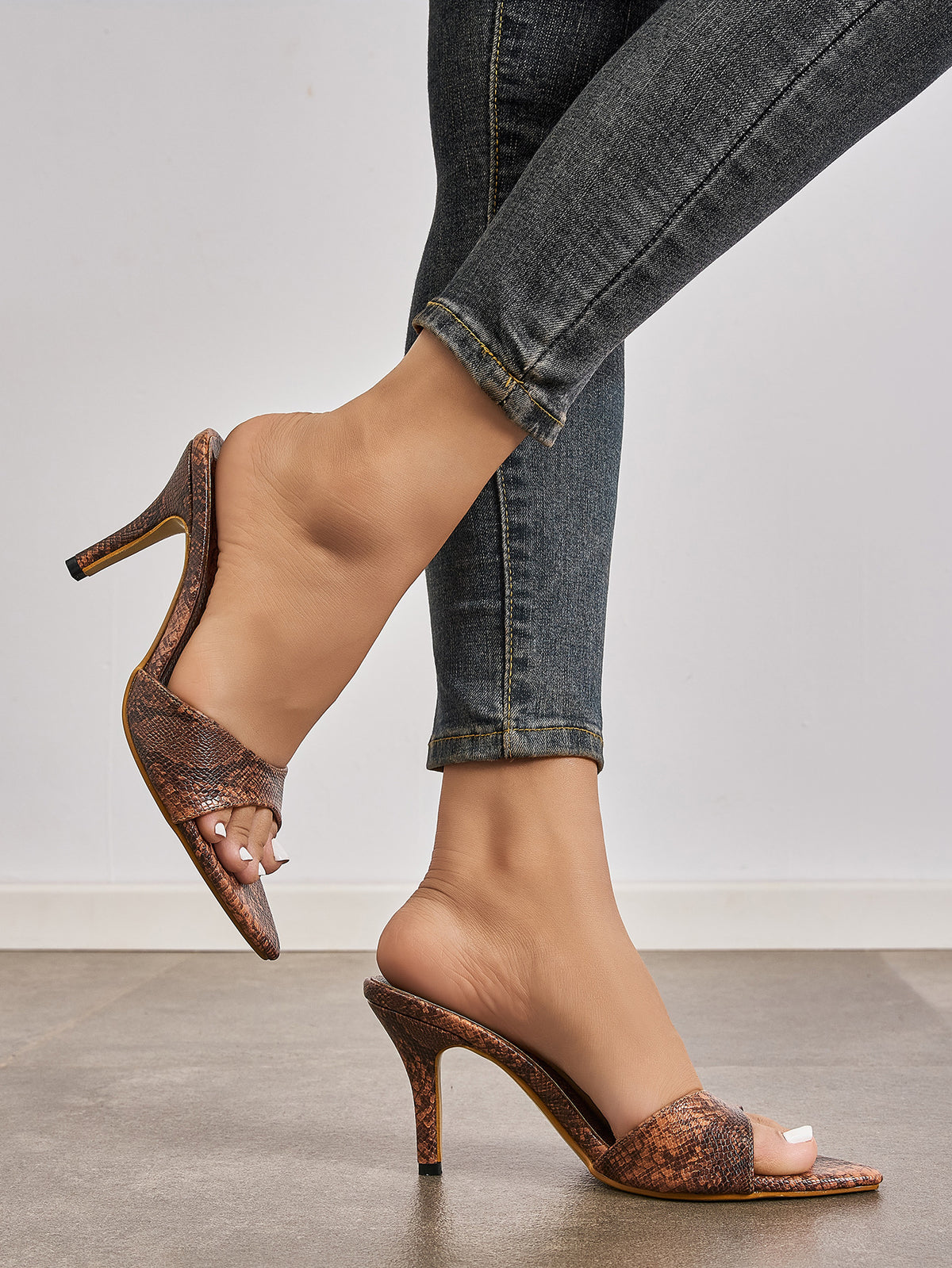 Mescini brown snake print pointed toe mule heels, worn with jeans, model walking, US women's sizes
